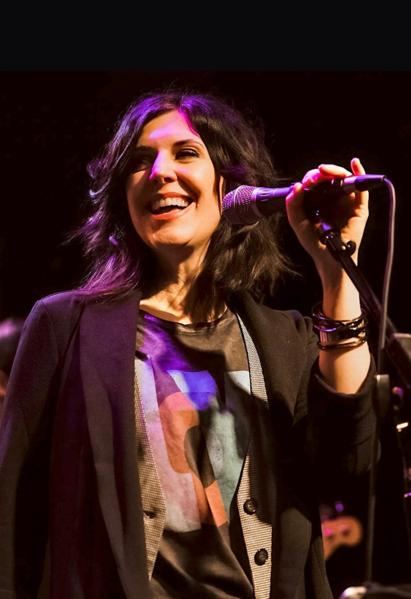 Jennifer Knight smiling at a microphone onstage